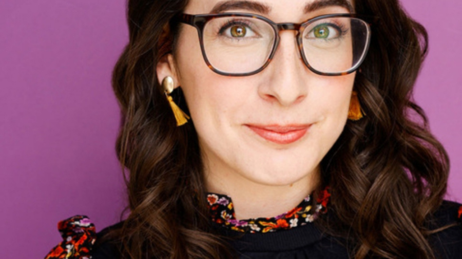 Liz Galalis smiling headshot wearing glasses and a flowery top